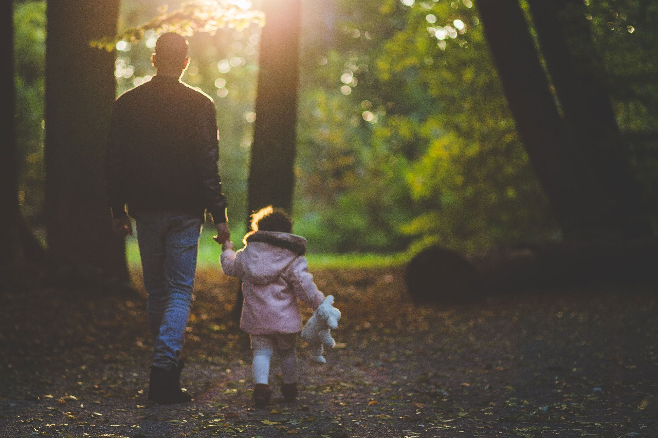Dad walking with his daughter in the forest